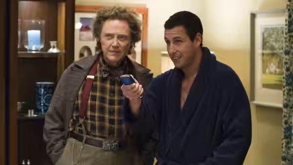 Morty (Christopher Walken) watches Michael Newman (Adam Sandler) examine a remote in a living room