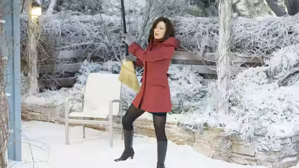 Donna Newman (Kate Beckinsale) sweeps snow from a garden path