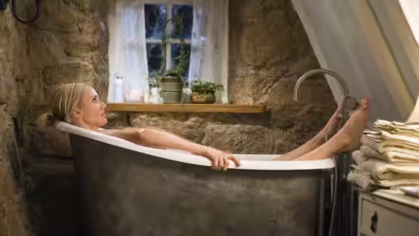 Amanda (Cameron Diaz) reclines in a bathtub in a stone cottage bathroom