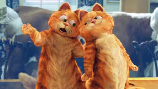 Garfield and Prince stand together among other cats, one gesturing outward