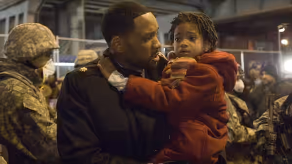 Robert Neville (Will Smith) holds Marley (Willow Smith) among soldiers at a military checkpoint