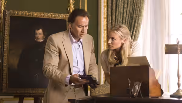 Ben Gates (Nicolas Cage) examines an object beside Abigail Chase (Diane Kruger) in a room with a portrait