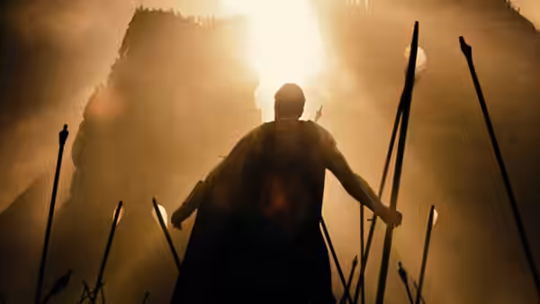 A Spartan warrior stands silhouetted before a towering enemy fortress