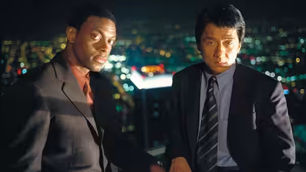 James Carter (Chris Tucker) and Yan Naing Lee (Jackie Chan) stand overlooking city lights