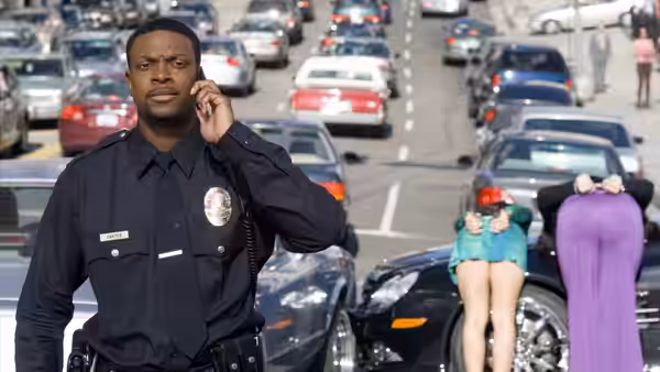 James Carter (Chris Tucker), dressed as a police officer, talks on his radio in traffic