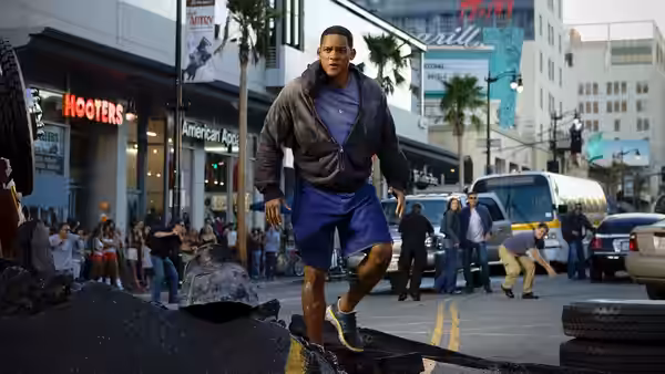 John Hancock (Will Smith) runs through a damaged street as bystanders flee