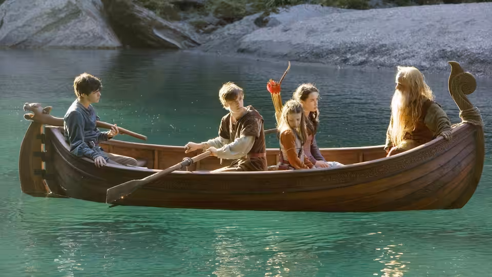 Four companions sit in a wooden boat crossing a clear mountain lake
