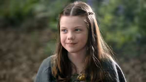 Lucy Pevensie (Georgie Henley) smiles beneath the trees