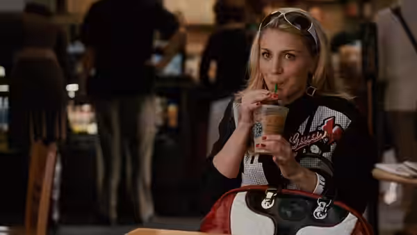 Samantha Jones (Kim Cattrall) sips a drink through a straw in a restaurant
