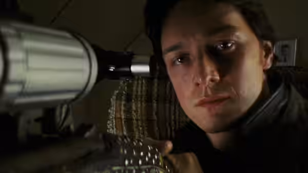 Wesley Gibson peers beside a large rifle fitted with a telescopic sight