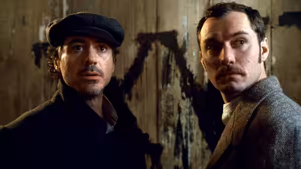 Sherlock Holmes (Robert Downey Jr.) and Dr. Watson (Jude Law) look toward something offscreen