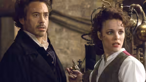 Sherlock Holmes (Robert Downey Jr.) and Irene Adler (Rachel McAdams) react inside a cluttered room
