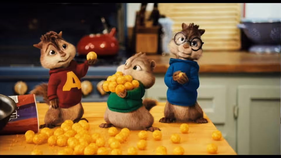 Alvin, Theodore, and Simon gather around scattered yellow snacks on a kitchen counter