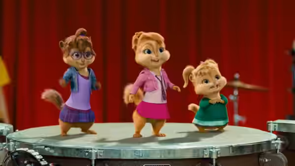 Jeanette, Brittany, and Eleanor stand together atop a drum before a red curtain