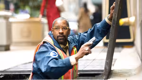 Walter Garber (Denzel Washington) climbs from a street access hatch