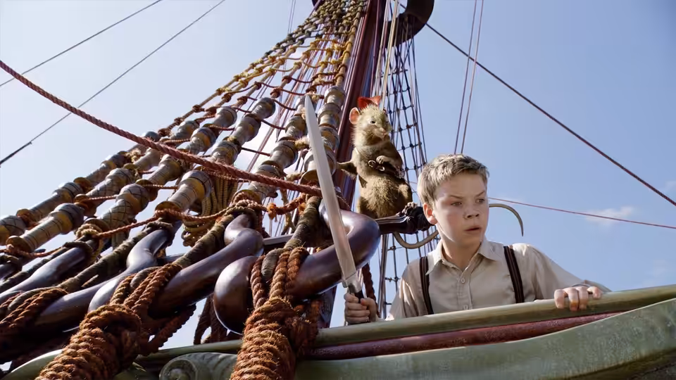 Eustace Scrubb (Will Poulter) grips the ship’s railing as Reepicheep climbs the rigging behind him