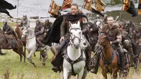 Robin Longstride (Russell Crowe) leads mounted soldiers across a grassy field