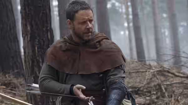 Robin Longstride (Russell Crowe) holds arrows in a misty forest