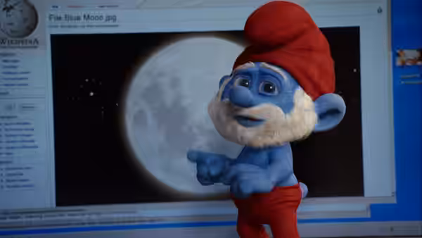 Papa Smurf points toward a moon on a computer screen