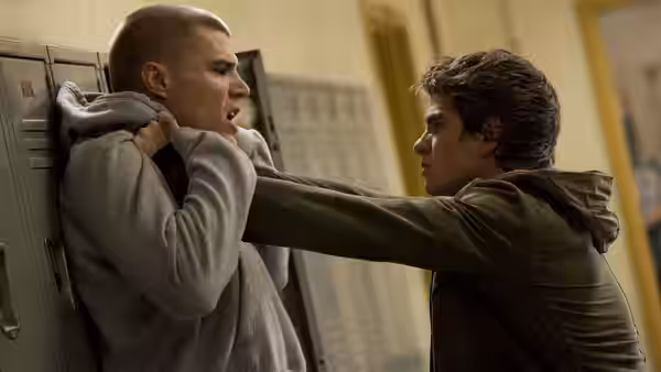 Peter Parker (Andrew Garfield) shoves Flash Thompson (Chris Zylka) against a school hallway locker