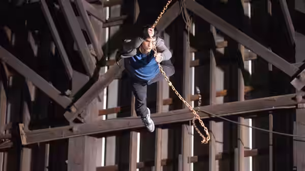 Peter Parker (Andrew Garfield) climbs among steel beams while tethered to a chain
