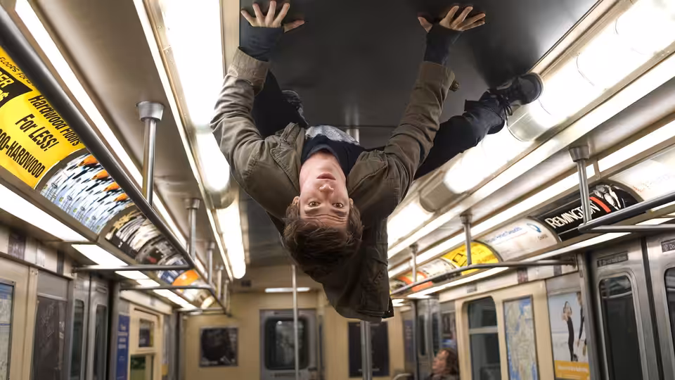 Peter Parker (Andrew Garfield) hangs upside down from the ceiling of a subway car