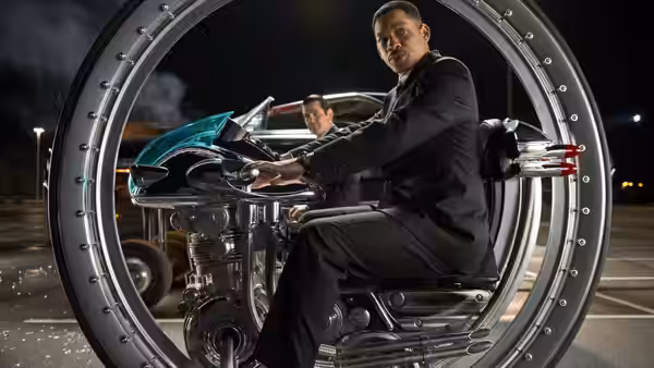 Agent J (Will Smith) sits astride a futuristic motorcycle inside a circular metal frame