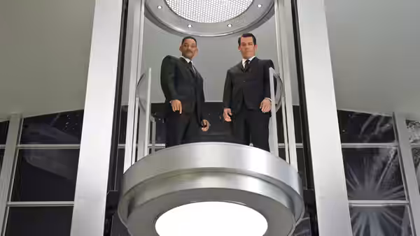 Agent J (Will Smith) and Young Agent K (Josh Brolin) stand in a glass elevator