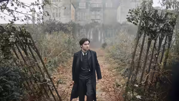 Arthur Kipps (Daniel Radcliffe) walks through an overgrown garden toward a mist-shrouded house