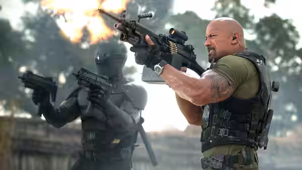 Roadblock (Dwayne Johnson) fires a heavy machine gun beside armored soldiers