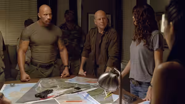 Roadblock (Dwayne Johnson), Joe Colton (Bruce Willis) and Lady Jaye study maps around a table