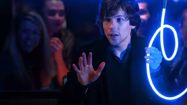 J. Daniel Atlas (Jesse Eisenberg) gestures beside a glowing blue stage prop