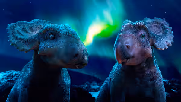 Two young dinosaurs stand beneath a glowing northern sky