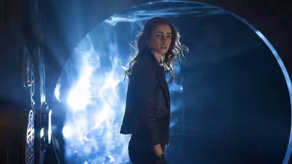 Clary Fray (Lily Collins) looks back beside a glowing circular portal