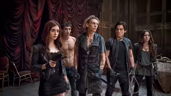 Clary Fray, Simon Lewis, Jace Wayland, Alec Lightwood, and Isabelle Lightwood stand armed in a room