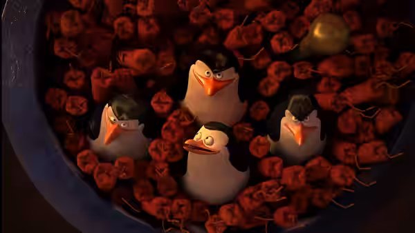 Four penguins peer out from a container packed with red bundles