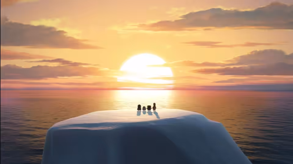 Four penguins stand together on an iceberg as the sun sets over the ocean