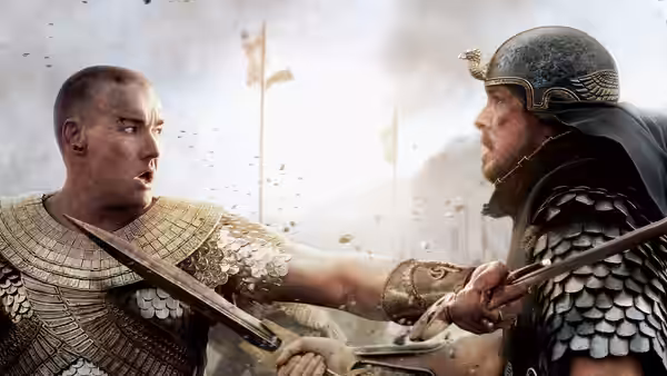 Moses (Christian Bale) and Ramses (Joel Edgerton) struggle at close quarters with swords on a battlefield