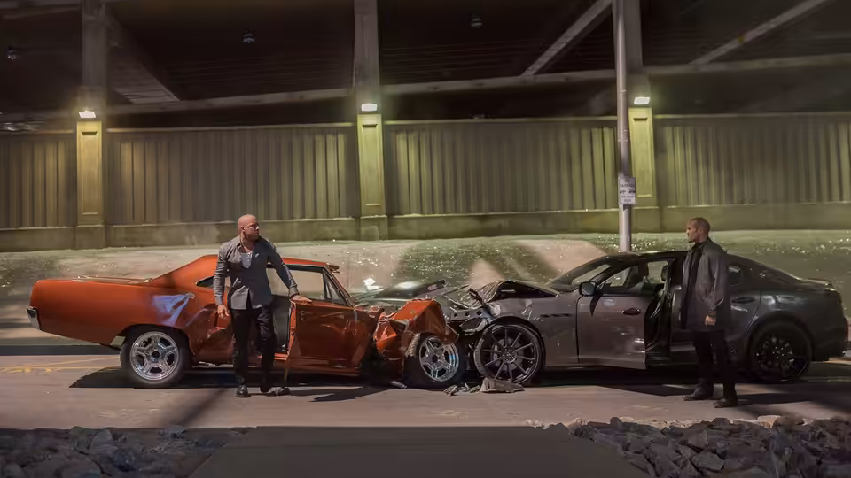 Dominic Toretto (Vin Diesel) and Deckard Shaw (Jason Statham) stand beside their wrecked cars