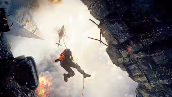 A rescue worker descends on a cable through a collapsing building as a helicopter approaches
