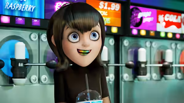Mavis smiles while holding a drink at a self-serve soda fountain
