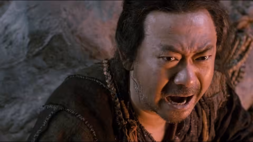 A rugged man cries out against a rocky backdrop