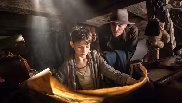 Peter Pan (Levi Miller) examines a map with James Hook (Garrett Hedlund) in a ship's hold
