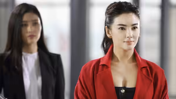 Ruolan (Zhang Yuqi) in a red jacket stands before another woman in an office