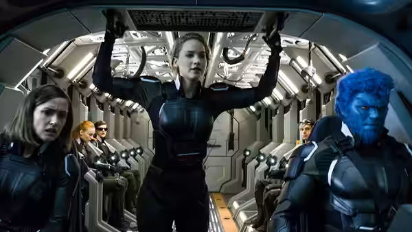 A woman raises her arms inside an aircraft cabin as blue-furred Beast sits nearby