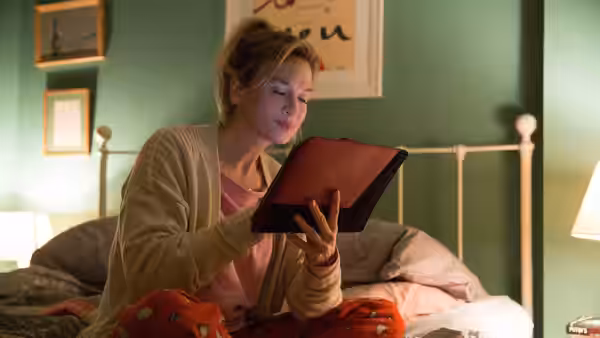 Bridget Jones (Renée Zellweger) sits in bed reading a tablet