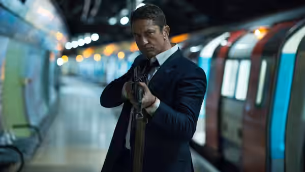 Mike Banning (Gerard Butler) aims a gun inside a brightly lit underground station