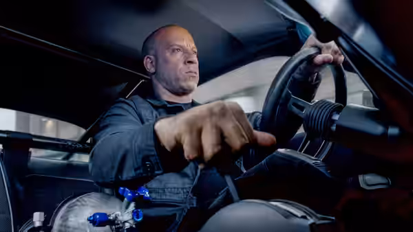 Dominic Toretto (Vin Diesel) grips the steering wheel while driving a car