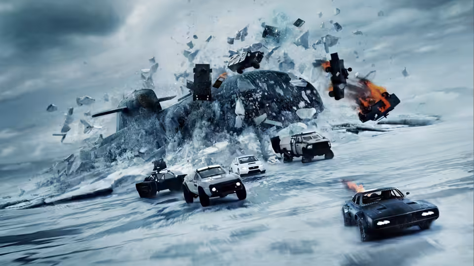 Cars race across an icy landscape as a helicopter crashes and debris erupts behind them