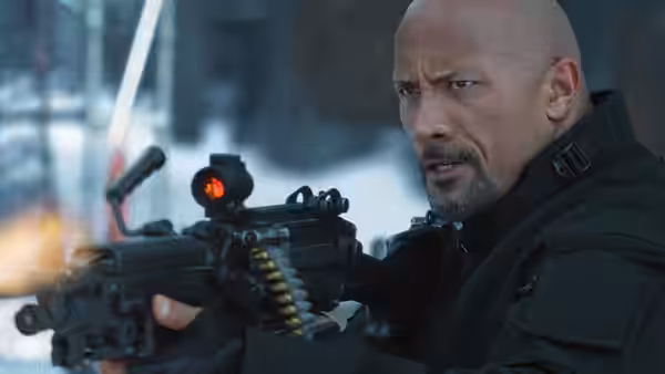Luke Hobbs (Dwayne Johnson) aims a machine gun in a snowy setting